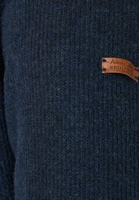 Dunkelblauer Strickpullover mit einem strukturierten Muster. Verfügt über ein Lederetikett mit der Aufschrift "AUTHENTIC CLOTHING REDMOND", das an der Seite angebracht ist.