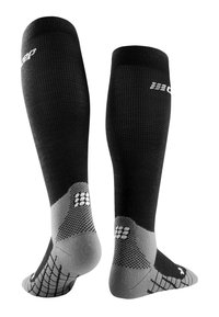 Schwarze knielange Socken mit grauem, texturiertem Fersen- und Zehenbereich; verfügen über ein Netzdesign und ein weißes Logo auf der Oberseite für Grip und Unterstützung.