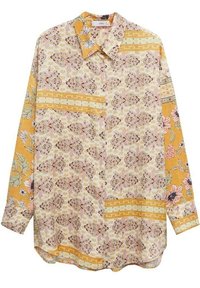 Chemise à motif floral avec une base jaune et des motifs roses et crème, col boutonné et manches longues. Tissu texturé avec des motifs mélangés.