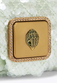 Groen gestructureerd clutch tasje met een goudkleurige rechthoekige sluiting met een decoratief schelpenontwerp en strass-accenten langs de randen.