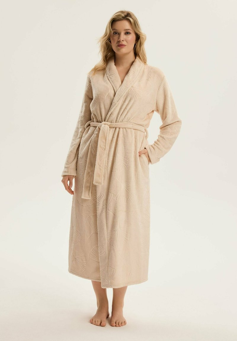 Beżowy szlafrok o teksturowanym wzorze przypominającym liście, z długimi rękawami, kołnierzem typu szal i pasującym paskiem, sięgający do połowy łydki.
