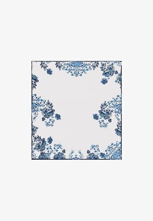 Kwadratowa biała chusta z misternymi niebieskimi wzorami kwiatowymi skoncentrowanymi wokół krawędzi i narożników.