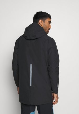 Black waterproof jacket with a hood, featuring reflective strips on the back and sleeves, and a mid-length design. Smooth texture.