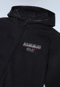 Zwarte hoodie met ritssluiting en hoge kraag, met een grafisch logo in wit en oranje op de linkerborst. Glad fabric en aansluitend ontwerp.