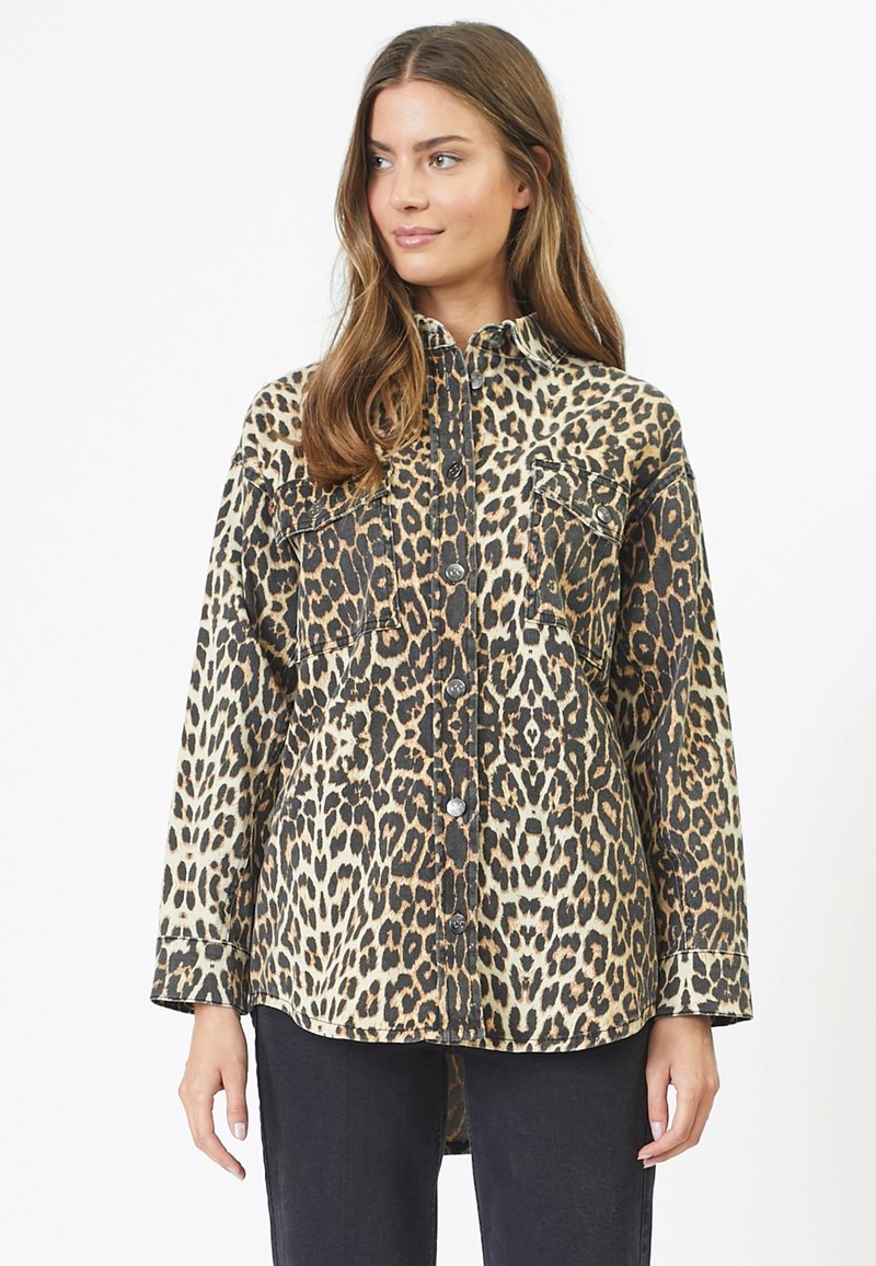 Luipaardprint shirt in beige en zwart, denim stof, lange mouwen, knoopsluiting aan de voorkant, twee borstzakken, relaxte pasvorm, gebogen zoom.
