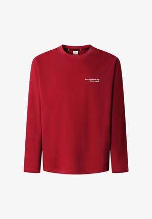 Czerwona koszula z długim rękawem wykonana z miękkiej tkaniny. Posiada okrągły dekolt i biały nadruk z napisem na lewej stronie klatki piersiowej. Prosty fason, bez dodatkowych ozdób.