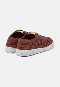 Sneakers marroni in rete con design a bassa punta e accenti gialli sul colletto. Suola in gomma bianca maculata. Materiale flessibile per il comfort.