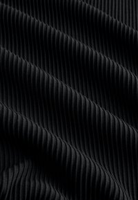 Schwarzer Rippstoff mit parallelen Rippen, weicher Textur und leicht glänzendem Finish, der sich in sanften Wellen legt.