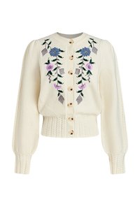 Cárdigan de color crema con bordado floral en azul y morado, botones dorados y un dobladillo de punto trenzado texturizado; mangas largas abullonadas.