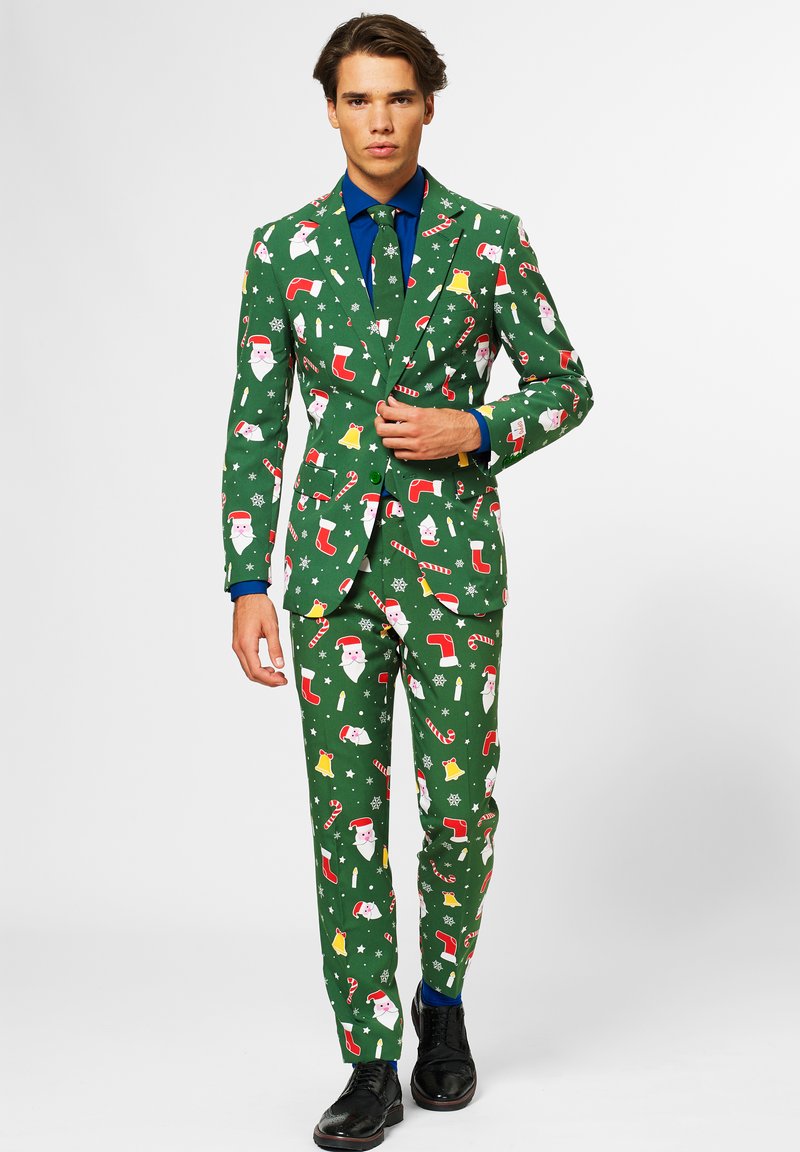 Completo verde con motivi a tema natalizio che includono Babbo Natale, calze, campane e bastoncini di zucchero; design slim fit, abbinato a una camicia blu.