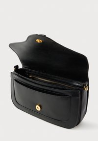 Schwarze Leder-Umhängetasche mit goldener Magnetklappe, Vorderfach und Reißverschluss-Hauptfach, Klappe geöffnet auf weißem Hintergrund.