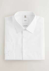 Zložená biela košeľa s klasickým golierom a manžetovým rukávom, s nášivkami „NEXT“ a „Cotton Rich“ vo vnútri goliera.
