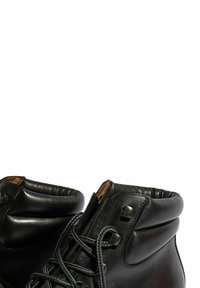 Botas de cuero negro con un alto cuello, superficie texturizada, puntera redonda y cinco ojales. Cuenta con un tobillo acolchado para mayor comodidad.