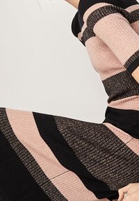 Sukienka dzianinowa z poziomymi paskami w odcieniach różowego i czarnego z metalicznymi akcentami. Teksturowany materiał z dopasowanym krojem i prążkowanymi detalami.