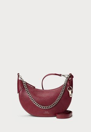 Sac à main en cuir bordeaux à la forme courbée, avec une chaîne en argent et une courte anse. Présente un logo et une texture lisse. Bandoulière amovible incluse.