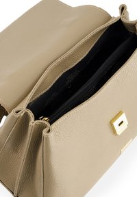 Sac à main en cuir beige avec une finition texturée, accents en métal doré, et un compartiment intérieur à double fermeture éclair. Doublure lisse.