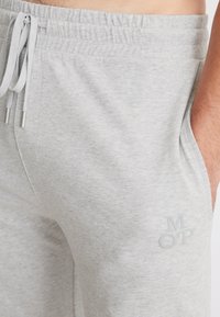 Lichtgrijze sweatpants van een zachte katoenmix, met een trekkoord in de taille, zijzakken en een subtiel geborduurd logo op de dij.