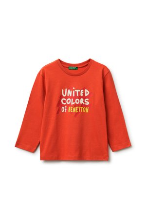 Oranges Langarmshirt mit dem Text "United Colors of Benetton" in Weiß und Gelb, vor einem roten Pinselstrich-Hintergrund hinter dem Text.