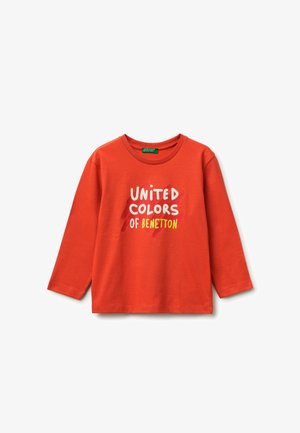 Maglietta arancione a maniche lunghe con il testo "United Colors of Benetton" in bianco e giallo, con uno sfondo a pennellate rosse dietro il testo.