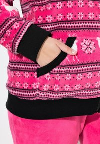 Felpa con cappuccio in rosa brillante, con un motivo di fiocchi di neve, polsini e vita a coste neri, e con una tasca frontale e dettagli con zip.