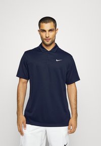 Schwarzes kurzärmliges Polohemd aus glattem Stoff, mit einem Drei-Knopf-Verschluss und einem kleinen weißen Nike-Logo auf der linken Brust.