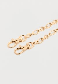 Αλυσίδα σε χρυσή απόχρωση με συνδεδεμένα οβάλ σχήματα, που διαθέτει δύο περιστρεφόμενα κλειδιά αστακού. Λείο, λαμπερό φινίρισμα με ομοιόμορφη υφή και σχέδιο.