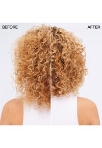 Kręcone blond włosy od tyłu, lewa strona puszysta i sucha, prawa strona gładsza i bardziej zdefiniowane loki, oznaczone jako przed i po.