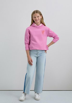 Sudadera corta de color rosa claro con un bolsillo tipo canguro y detalles en gris; combinada con pantalones vaqueros de pierna ancha en azul claro con una franja lateral en azul oscuro.