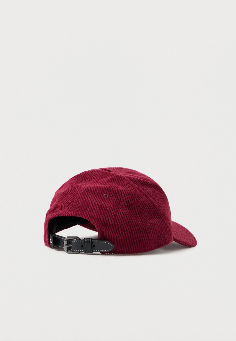 Gorra de pana burdeos con visera curva, correa negra ajustable en la parte trasera y ojales de ventilación a los lados.