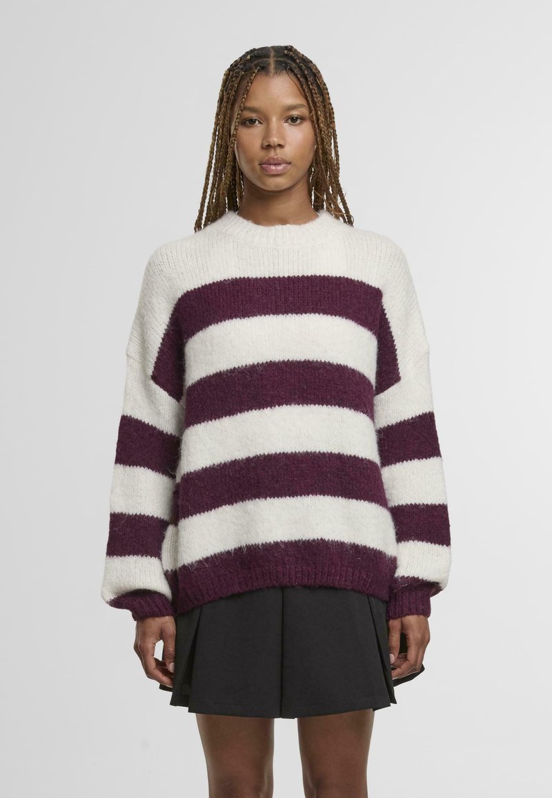 Megztinis su didelėmis bordo ir baltomis juostomis, apvalia iškirpte, nusmukusiais pečiais ir ribotais rankogaliais. Minkšta, pūkuota tekstūra, perteptas dydis.