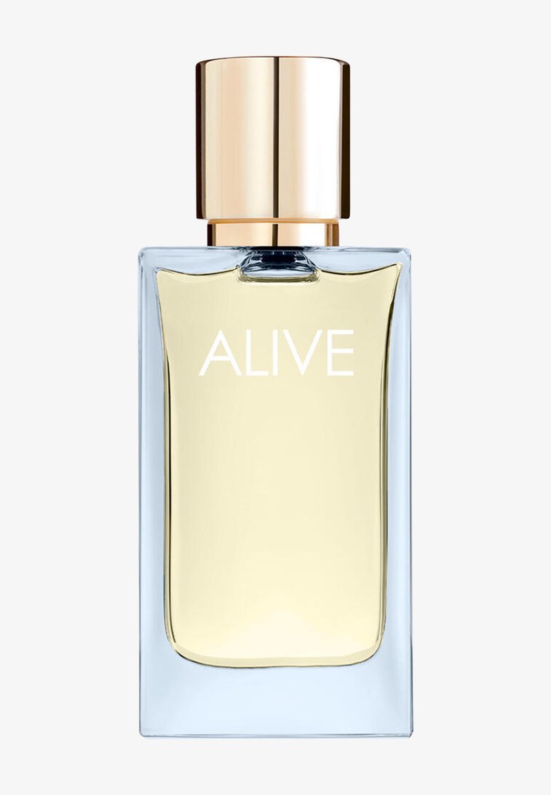 Doorzichtige rechthoekige parfumfles met lichtgele vloeistof, gouden dop, en "ALIVE" in het wit gedrukt op de voorkant.