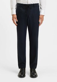 Navy trousers with a drawstring waist, straight leg design, and a smooth texture. Worn with black leather shoes.