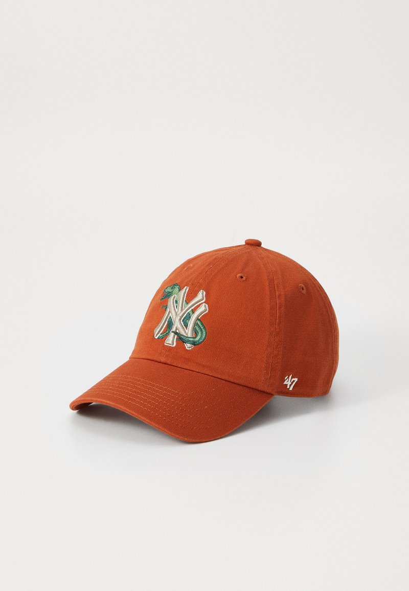 Rust-colored cap featuring embroidered green and white logo on the front, curved brim, and "47" logo on the side. Cotton fabric.