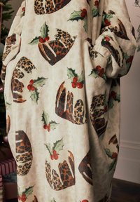 Fliiskangas, millel on kreemikas taust koos leopardimustriliste ja punaste mustikatega pihlaka lehtede motiividega, lõigatud ülemõõdus kujundisse.