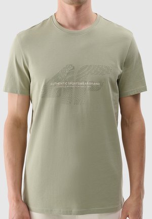 Oliwkowa koszulka wykonana z miękkiej bawełny. Posiada okrągły dekolt i krótkie rękawy z graficznym nadrukiem nazwy marki na klatce piersiowej.