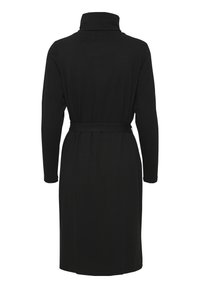 Svart långärmad klänning med hög hals, bälte i midjan och knälång längd. Slät textur med en enkel, elegant silhuett.