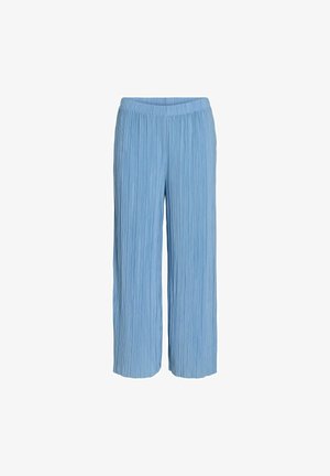 Pantalons plissés larges de couleur bleu clair, dotés d'une taille élastique. Fabriqués en tissu texturé. Ils tombent au milieu du mollet sans fermetures visibles.
