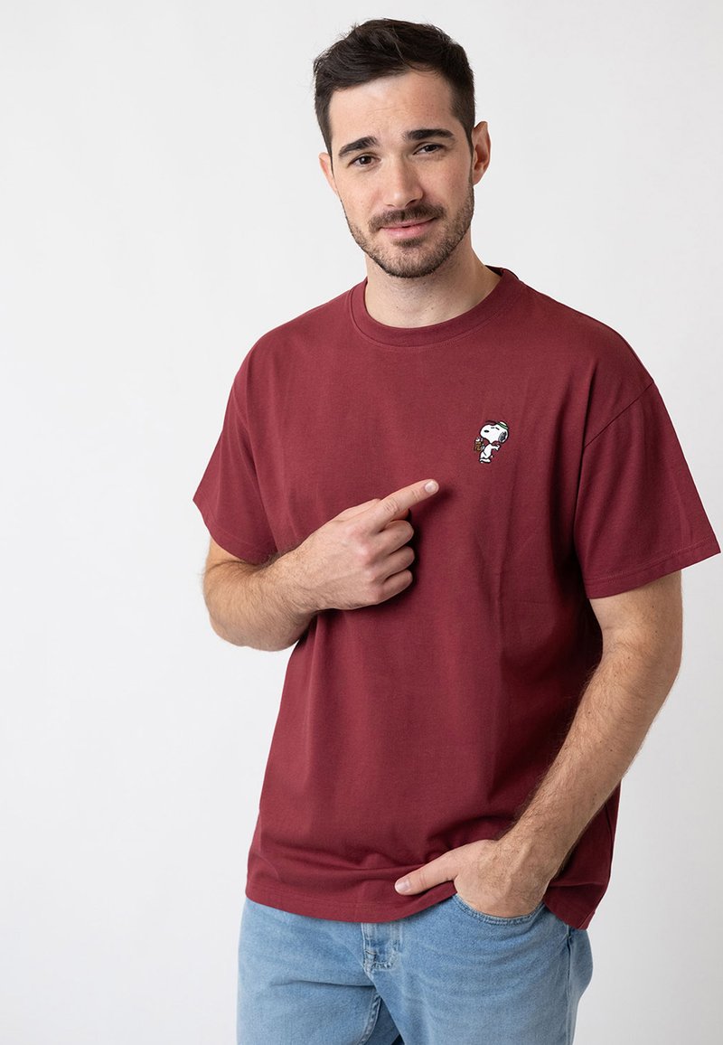 Maroon cotton t-shirt with short sleeves, featuring a small embroidered Snoopy graphic on the chest. Relaxed fit with a round neckline.