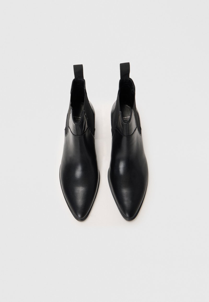 Bottines en cuir noir avec un bout pointu, des panneaux élastiques sur les côtés et des tirettes. Texture lisse avec un design minimaliste.