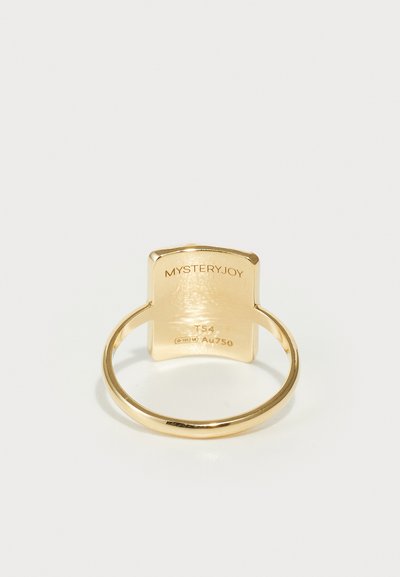 Anillo de oro con una parte superior plana en forma de escudo. Grabados de marca y detalles en la parte interior de la banda. Acabado suave y pulido, diseño minimalista.