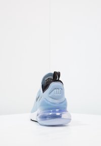 Light blue sneaker with a mesh upper, black accents, and a translucent air-cushioned sole. Back features the "Air" logo on the heel.