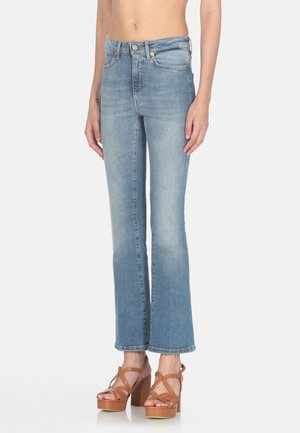 Jeans in denim azzurro chiaro a gamba larga con vita alta, sbiaditure leggere e dettagli in rivetti di rame. Abbinati a sandali con plateau marroni.