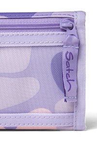 Lila Stofftasche mit Reißverschluss, subtilen Mustern aus großen und kleinen Kreisen in verschiedenen Farbtönen und einem angenähten Etikett mit "Satch".