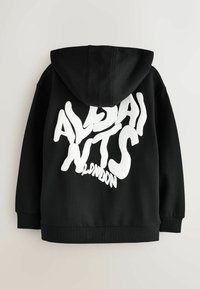 Černá mikina s kapucí s velkým stylizovaným bílým textem "ALPHA NTS LONDON" na zádech, s kapucí na šňůrky a žebrovanými manžetami.