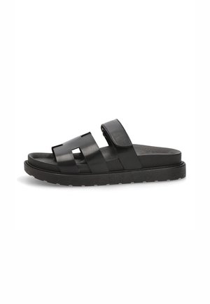 Chanclas negras con dos correas anchas y planas, hechas de material suave; con una plantilla texturizada y una suela plana duradera.