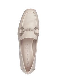 Scarpa slip-on in pelle beige con punta tondeggiante, caratterizzata da un'accento di catena metallica e cuciture sottili. Texture liscia, design minimalista.