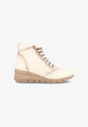 Botas de tobillo beige con un upper de piel suave, cordones grises texturizados y una suela gruesa beige con ranuras para tracción.