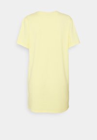 Gele katoenen t-shirt met een relaxte pasvorm, korte mouwen en een ronde hals. De achterkant is eenvoudig zonder extra details of patronen.