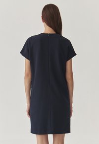 Navy blue casual dress with short sleeves, a straight cut, and a back zipper closure, showcasing a smooth fabric texture.