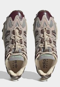 Ζευγάρι αθλητικών παπουτσιών Adidas Adventure σε μπεζ, καφέ και μπορντό, με επενδύσεις από δίχτυ και δέρμα, εμφανιζόμενο από τη πάνω πλευρά.